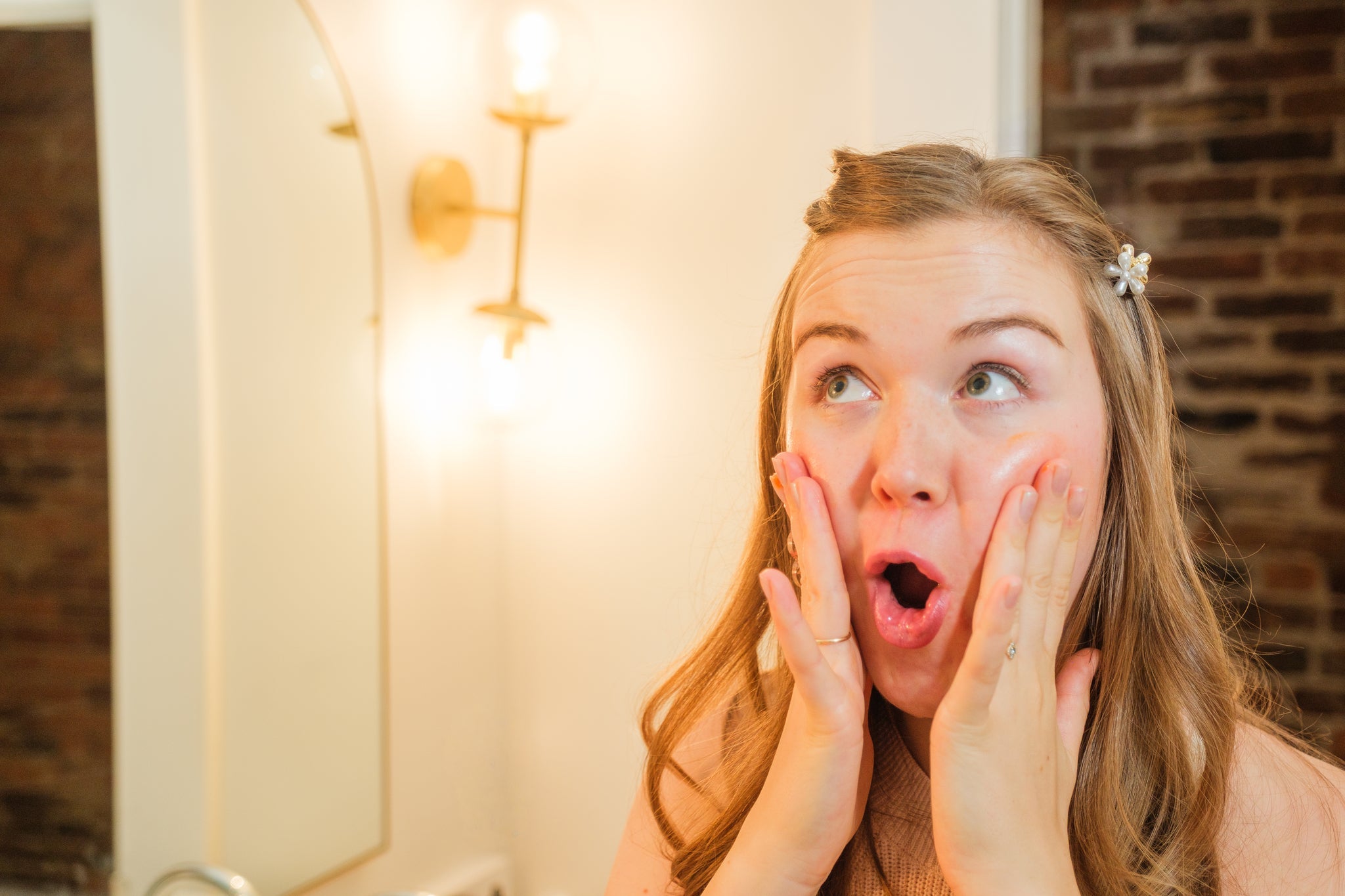 Business owner making fish face while applying moisturizer