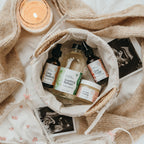 Skincare products from Mira Motte Postpartum Bundle in a basket with a candle and photos on a soft surface