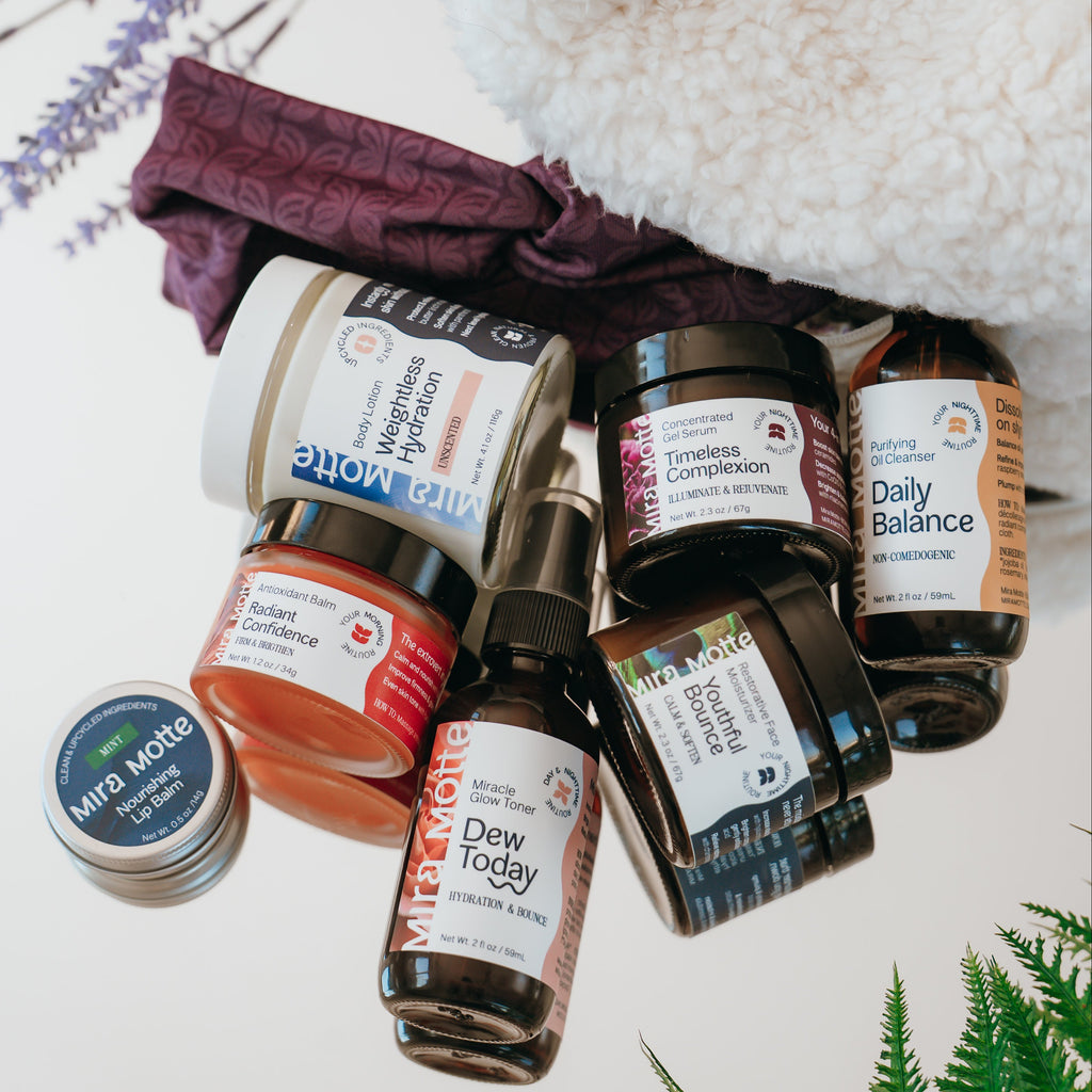 Collection of Mira Motte skincare products including bottles and jars on a mirror with plants in the background.