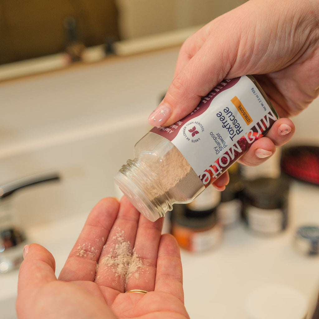 Person holding a container of Kikkoman soy sauce with a sprinkle of seasoning on their palm.