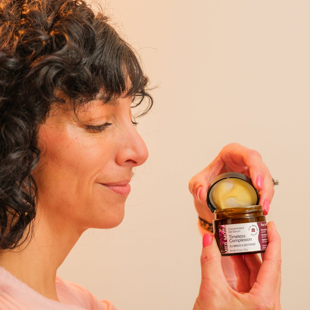 Woman holding Mira Motte "Timeless Complexion" Concentrated Gel Serum  against a plain background